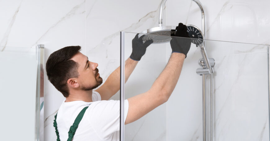 Plumber installing new shower head to save water at home