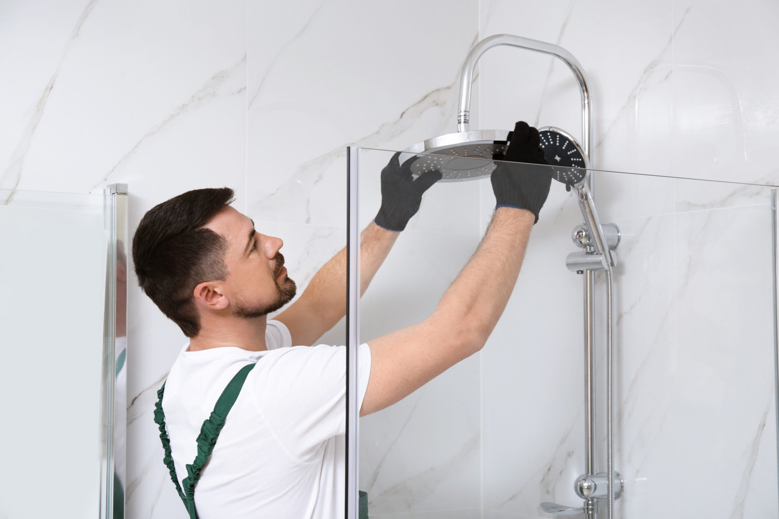 Plumber installing new shower head to save water at home